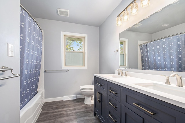 2228 Washington Ave, Saint Joseph, MI 49085 - bathroom with toilet, wood finished floors, double vanity, baseboards, and shower / bathtub combination with curtain