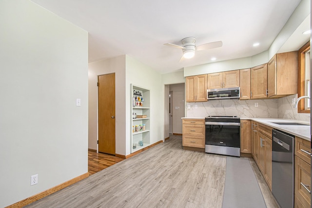2228 Washington Ave, Saint Joseph, MI 49085 - kitchen featuring stainless steel appliances, a sink, light wood-type flooring, a ceiling fan, and backsplash