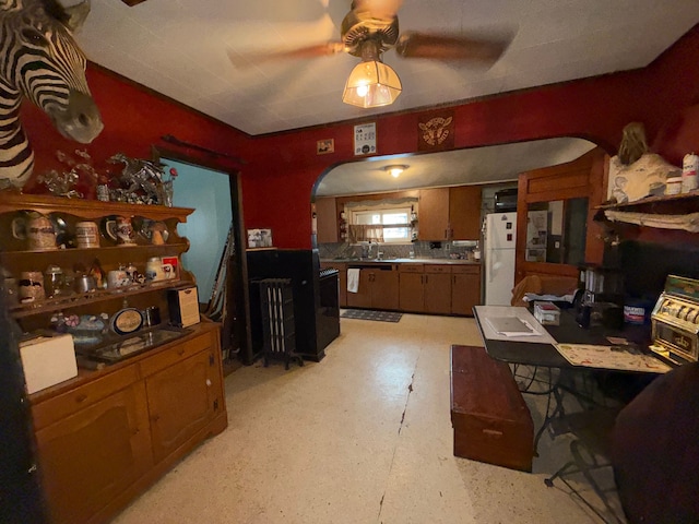 dining area featuring arched walkways and a ceiling fan
