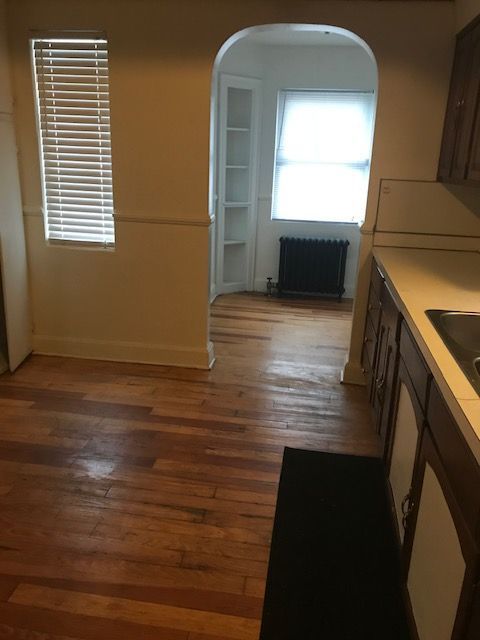 17311 Santa Rosa Dr, Detroit, MI 48221 - dining room featuring radiator, wood finished floors, baseboards, and arched walkways