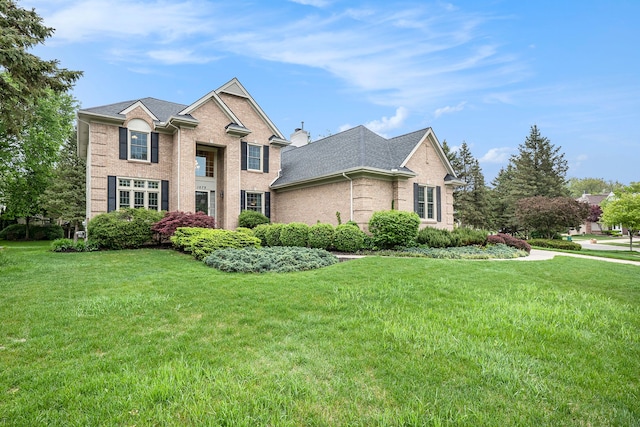 1079 Trailside Blvd, Wixom, MI 48393 - traditional-style house with a front yard, brick siding, and a shingled roof