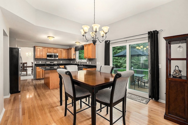 1079 Trailside Blvd, Wixom, MI 48393 - dining space with a chandelier, light wood-type flooring, and baseboards