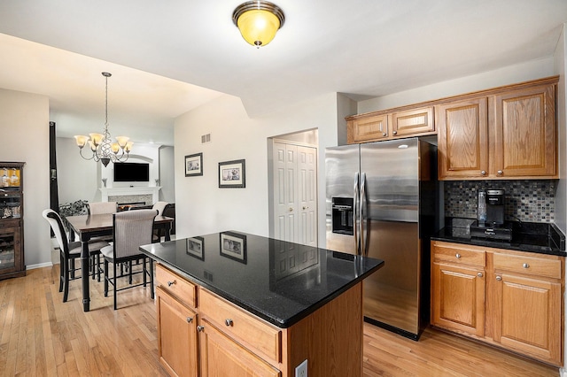 1079 Trailside Blvd, Wixom, MI 48393 - kitchen with stainless steel fridge with ice dispenser, light wood finished floors, decorative backsplash, a center island, and a chandelier