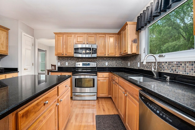 1079 Trailside Blvd, Wixom, MI 48393 - kitchen with stainless steel appliances, a sink, light wood-type flooring, and backsplash