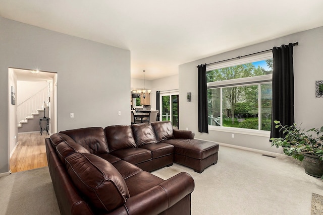 1079 Trailside Blvd, Wixom, MI 48393 - carpeted living room with stairs, a chandelier, and baseboards