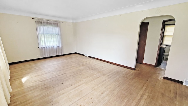 2127 E Coldwater Rd, Flint, MI 48505 - empty room featuring arched walkways, wood finished floors, and baseboards