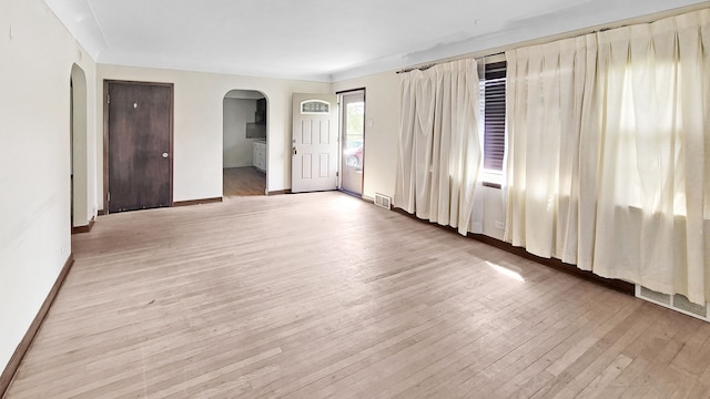2127 E Coldwater Rd, Flint, MI 48505 - unfurnished room featuring arched walkways, light wood-type flooring, and baseboards