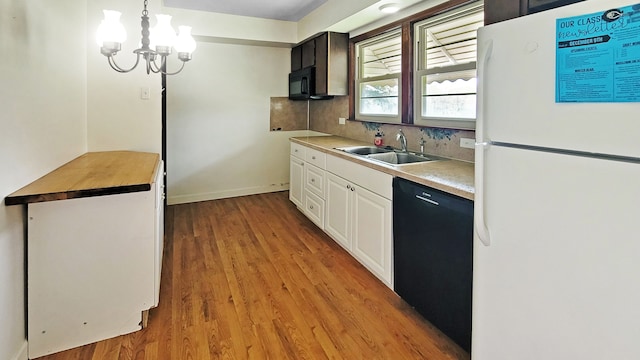 2127 E Coldwater Rd, Flint, MI 48505 - kitchen with black appliances, a sink, light wood-style floors, white cabinetry, and tasteful backsplash