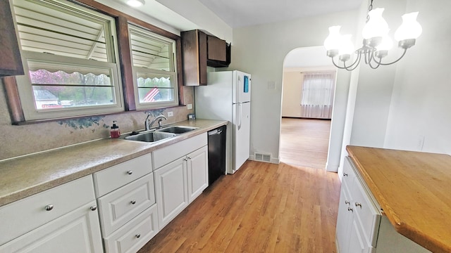 2127 E Coldwater Rd, Flint, MI 48505 - kitchen featuring a sink, black dishwasher, wooden counters, light wood-style floors, and a chandelier