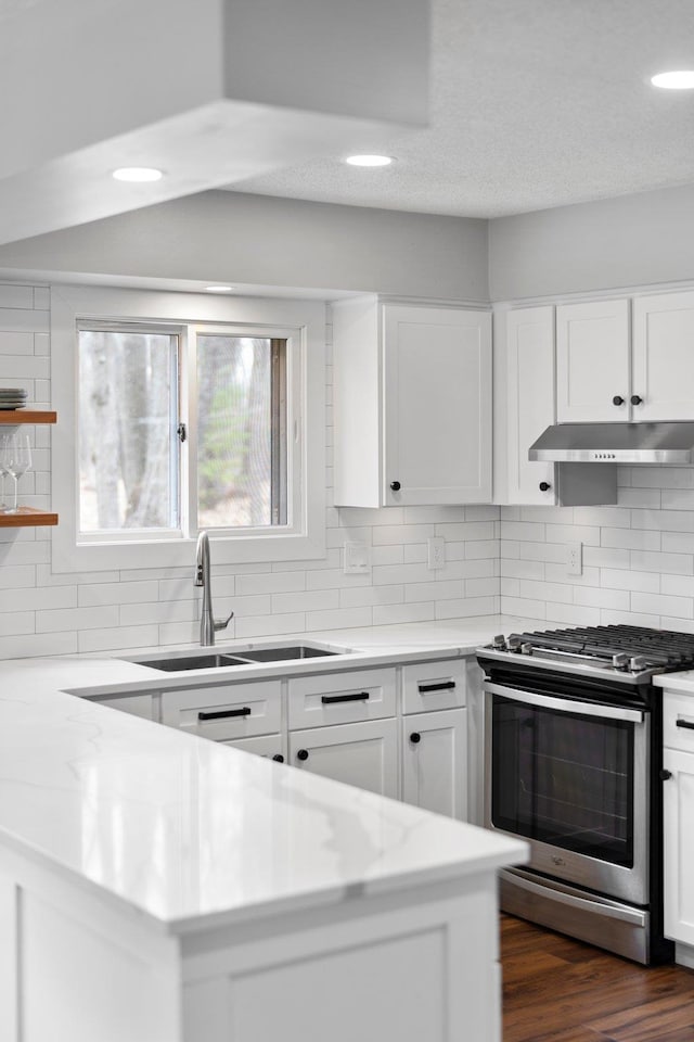 kitchen with gas range, a sink, decorative backsplash, recessed lighting, and white cabinetry