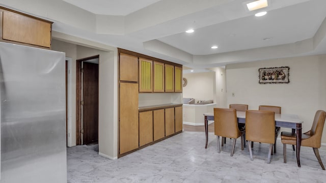 dining area with light marble finish flooring, a tray ceiling, and recessed lighting