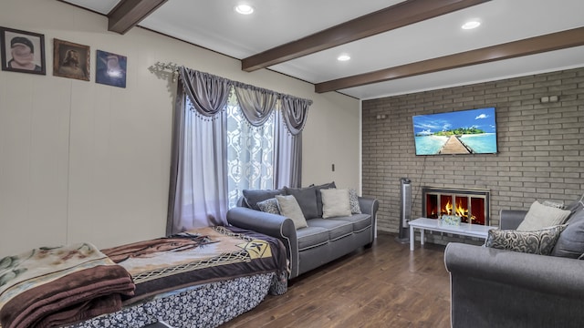 living room with beam ceiling, dark wood-type flooring, a fireplace, recessed lighting, and brick wall