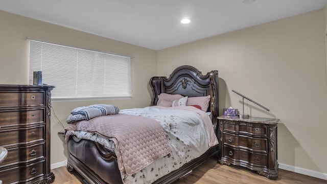 bedroom with wood finished floors, baseboards, and recessed lighting