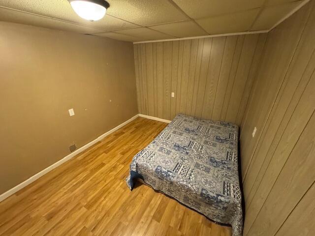 205 Wren Rd, Sturgis, MI 49091 - bedroom featuring wood finished floors, baseboards, and wood walls