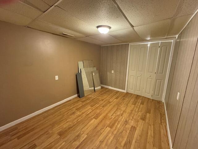 205 Wren Rd, Sturgis, MI 49091 - finished basement featuring a paneled ceiling, light wood-type flooring, baseboards, and wooden walls