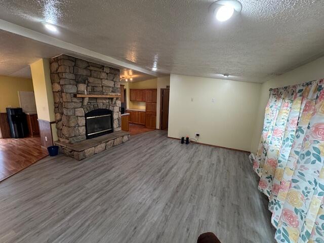 205 Wren Rd, Sturgis, MI 49091 - unfurnished living room with a textured ceiling, light wood-style floors, and a fireplace