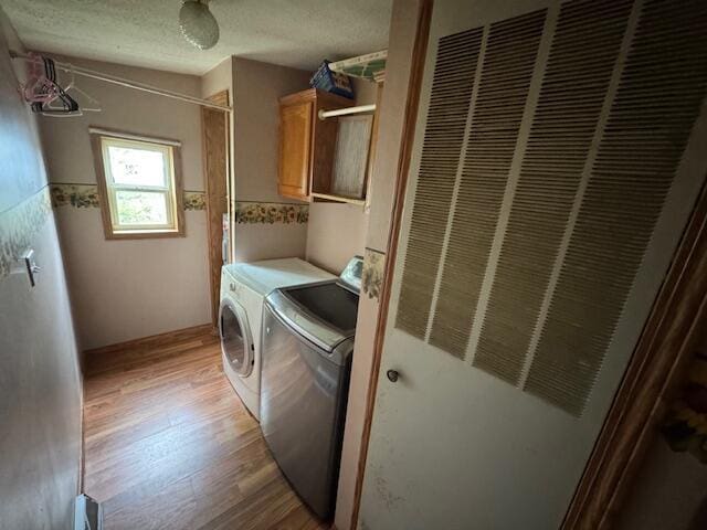 205 Wren Rd, Sturgis, MI 49091 - laundry area with separate washer and dryer, a heating unit, cabinet space, light wood-style floors, and a textured ceiling