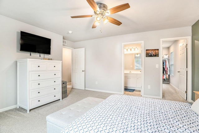 bedroom with light carpet, baseboards, and ensuite bathroom