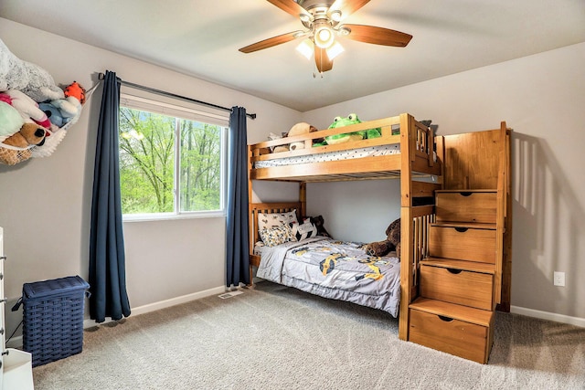 carpeted bedroom featuring baseboards and ceiling fan