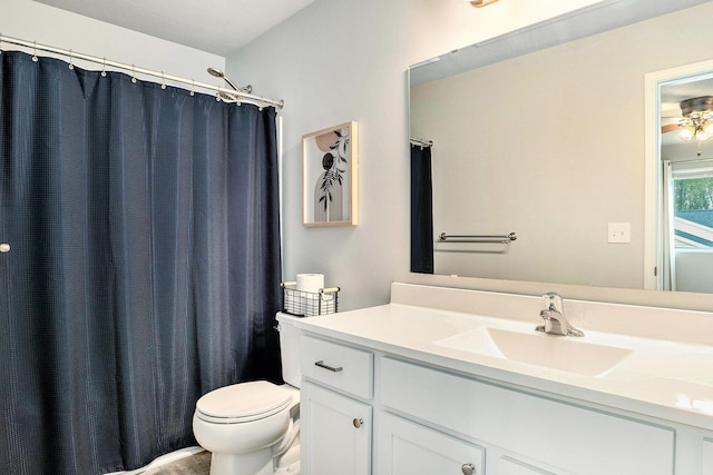 bathroom featuring vanity, toilet, and ceiling fan