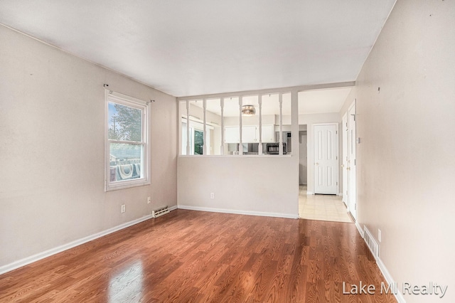 unfurnished living room featuring wood finished floors and baseboards