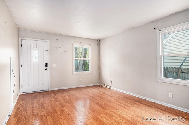 foyer featuring light wood-style floors and baseboards