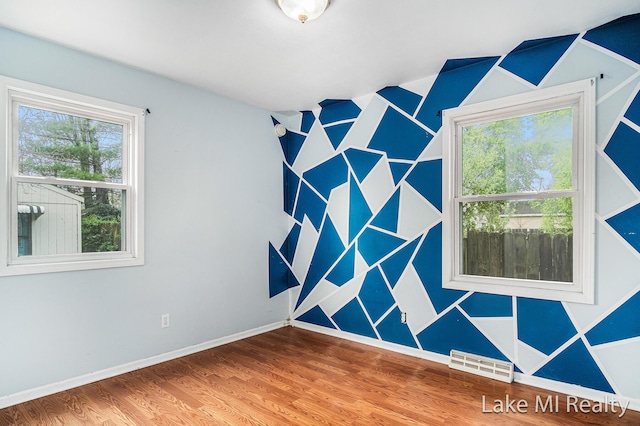 spare room with wood finished floors and baseboards