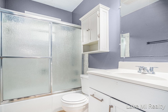 bathroom with vanity, bath / shower combo with glass door, and toilet