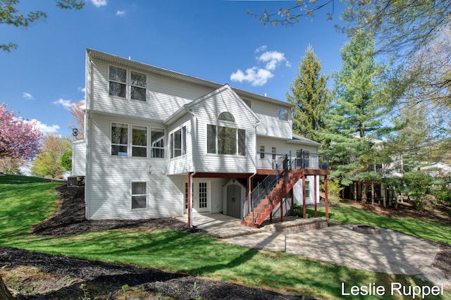 back of house featuring a fire pit, a patio area, stairs, a deck, and a lawn
