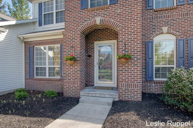 doorway to property featuring brick siding