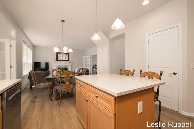 kitchen featuring a kitchen breakfast bar, light wood-style floors, dishwasher, open floor plan, and a kitchen island