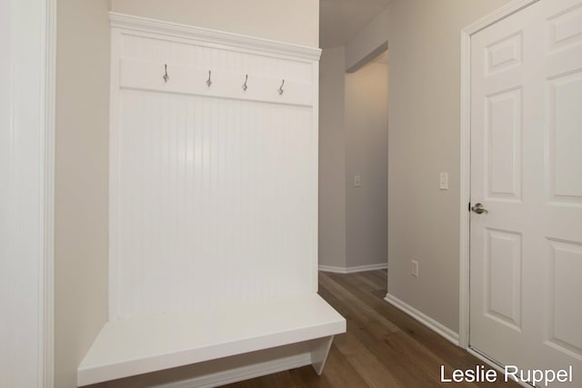 mudroom with dark wood-style flooring and baseboards