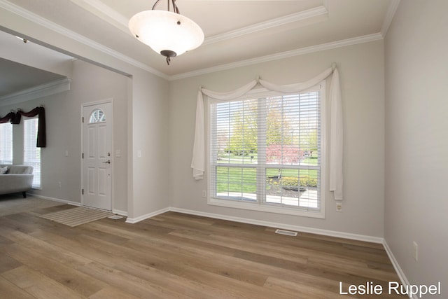 unfurnished room with wood finished floors, baseboards, and ornamental molding