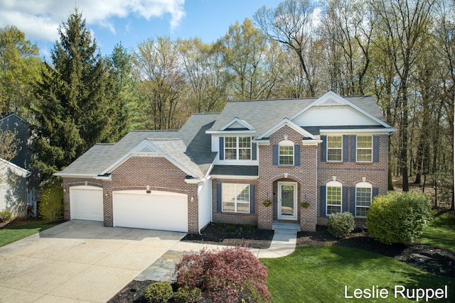 view of front of property featuring a garage, concrete driveway, and brick siding