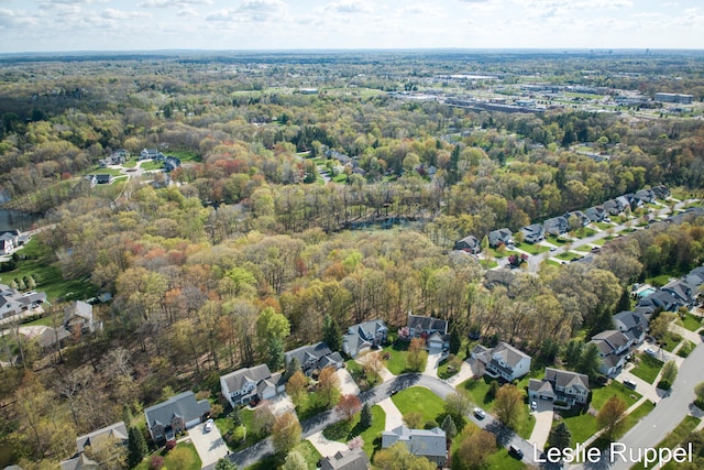 aerial view of property's location with a heavily wooded area and nearby suburban area
