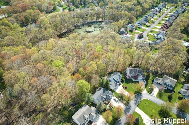 view of property location featuring a forest and nearby suburban area