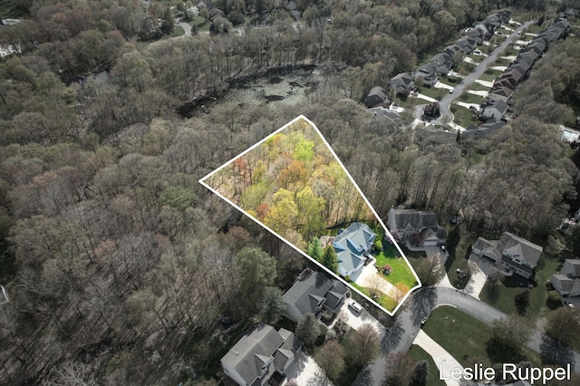aerial perspective of suburban area with a heavily wooded area and property boundaries highlighted
