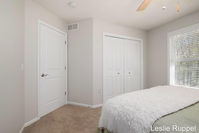 bedroom with carpet, a closet, baseboards, and ceiling fan