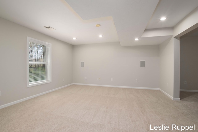 spare room with light colored carpet, recessed lighting, and baseboards