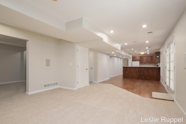 unfurnished living room featuring light colored carpet, recessed lighting, and baseboards