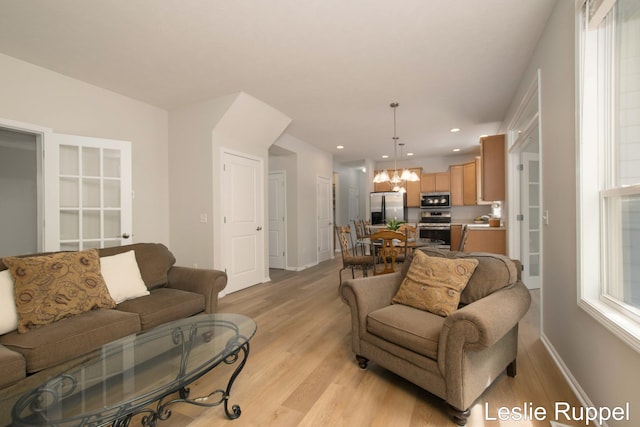 living area featuring light wood-type flooring, baseboards, a chandelier, and recessed lighting