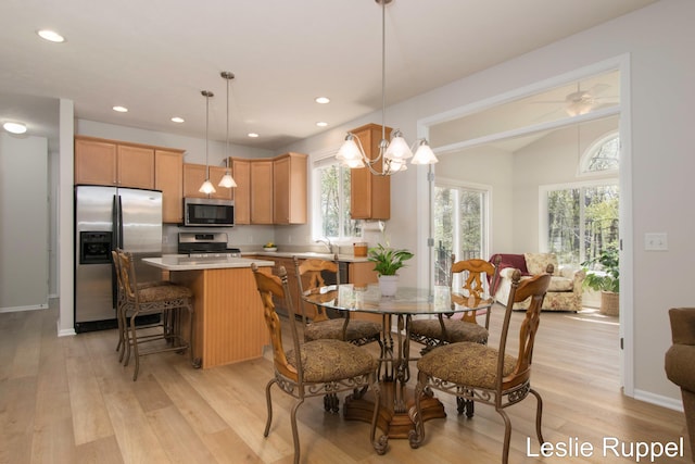 dining area featuring light wood-style floors, vaulted ceiling, and recessed lighting