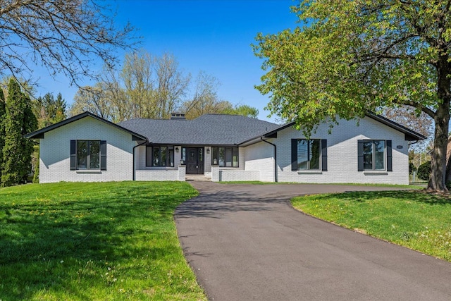 ranch-style house featuring brick siding, driveway, and a front yard