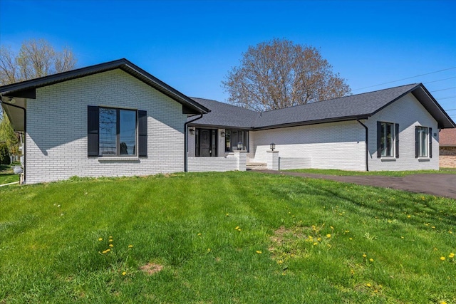 single story home with brick siding and a front yard