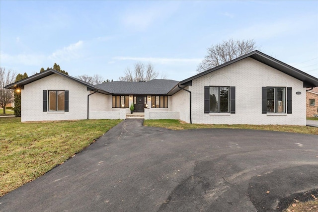 view of front of home featuring brick siding and a front yard