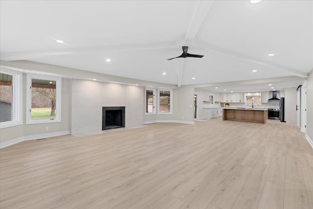 unfurnished living room featuring light wood-style floors, a ceiling fan, a fireplace, baseboards, and recessed lighting