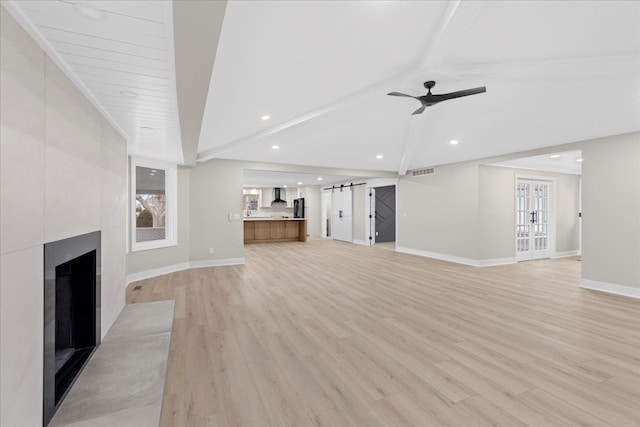 unfurnished living room with light wood finished floors, baseboards, a tile fireplace, ceiling fan, and recessed lighting