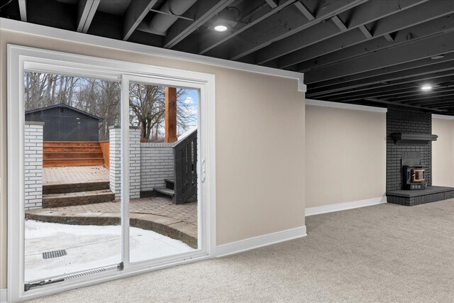 basement featuring carpet flooring, baseboards, a fireplace, and stairs