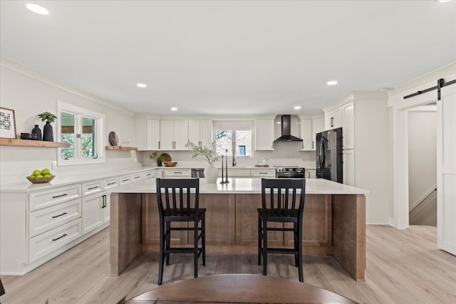 kitchen featuring freestanding refrigerator, a barn door, open shelves, white cabinetry, and recessed lighting