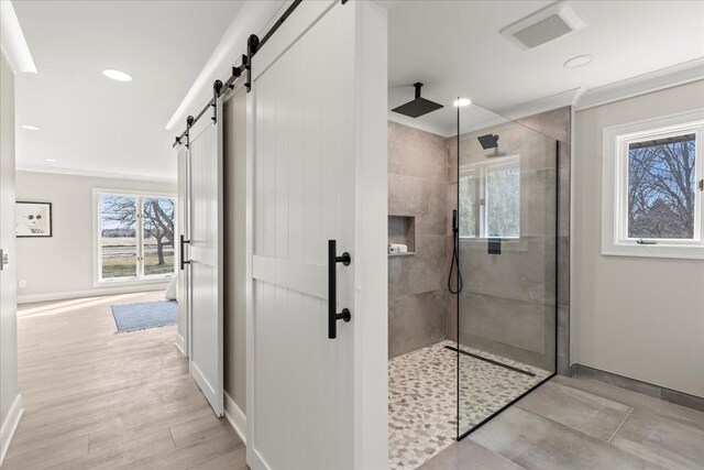 bathroom featuring a walk in shower, baseboards, recessed lighting, crown molding, and wood finished floors